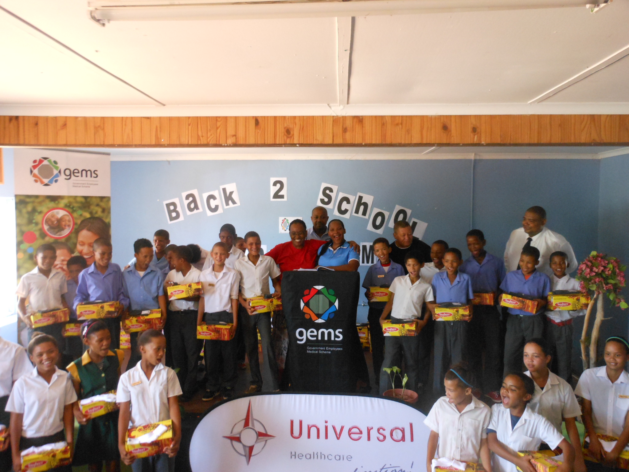Excited Grade 7 learners receiving their school shoes and socks with Ms. Lindelwa 